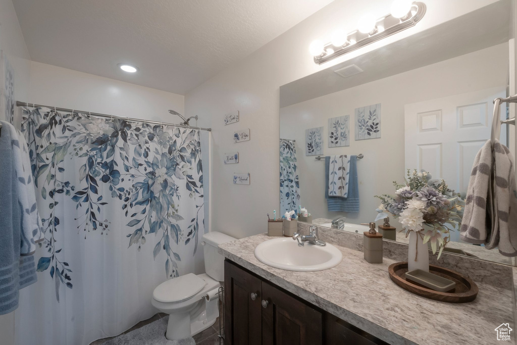 Full bath featuring vanity, toilet, and a shower with curtain