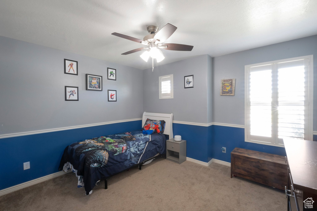 Carpeted bedroom with baseboards and a ceiling fan