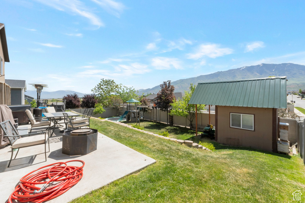View of yard featuring a playground, a mountain view, and a patio