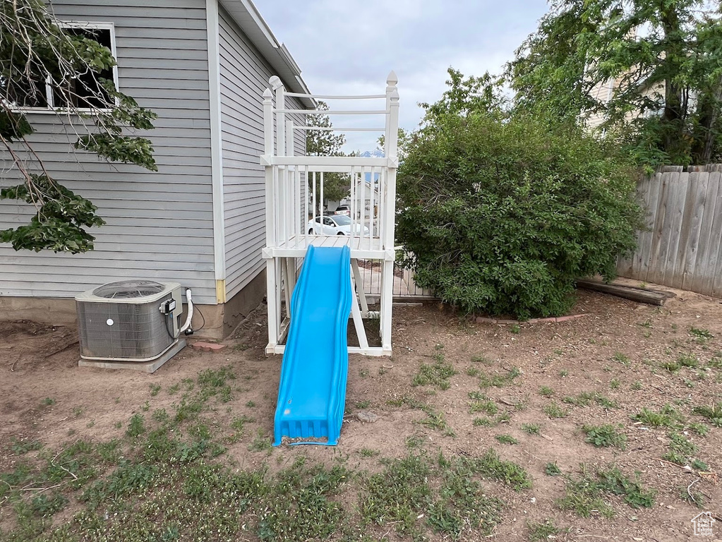 View of yard with central air condition unit and a playground
