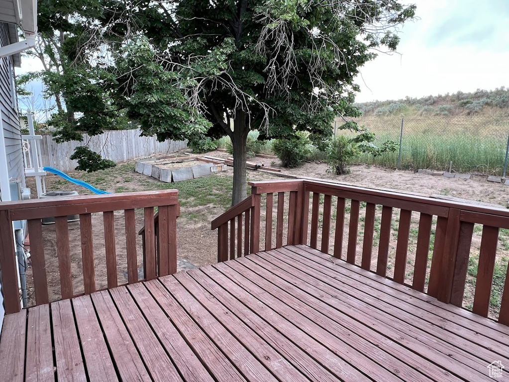 Wooden terrace with a fenced backyard