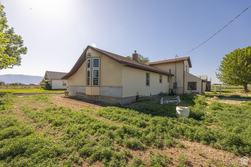 Back of property with a chimney and brick siding