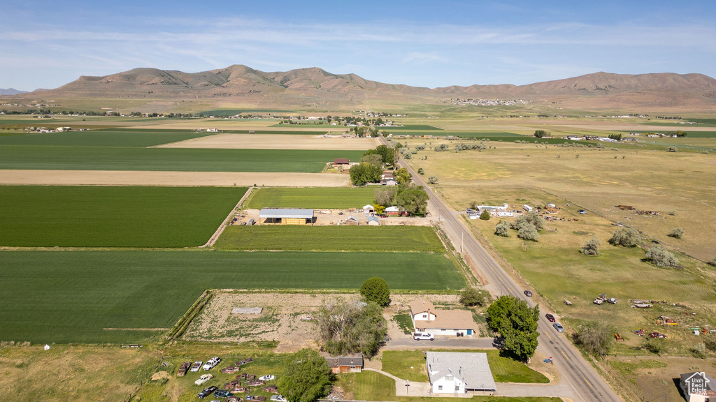 Aerial view of property and surrounding area with rural landscape, a mountain backdrop, and farmland