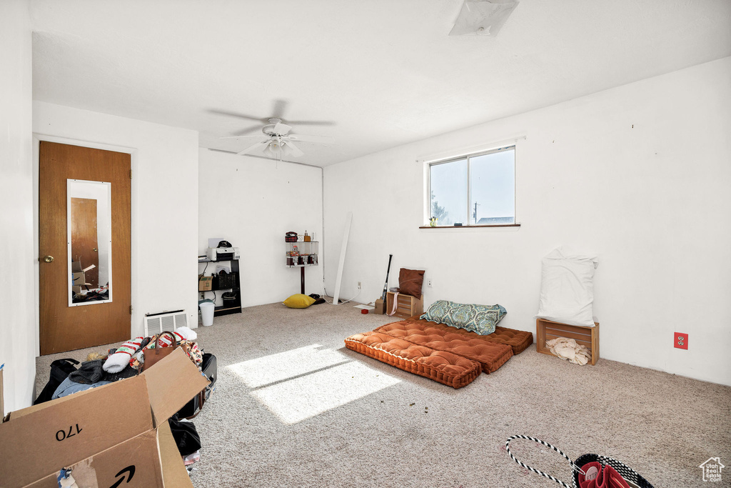 Living area with carpet floors and a ceiling fan