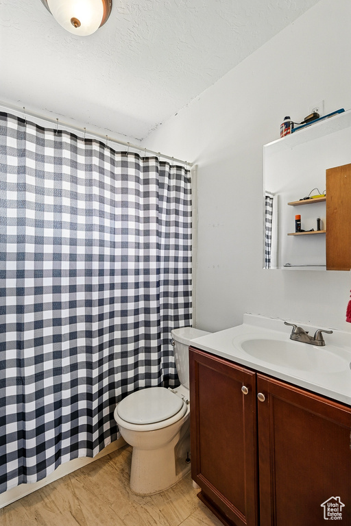 Full bath with toilet, vanity, a textured ceiling, and a shower with shower curtain