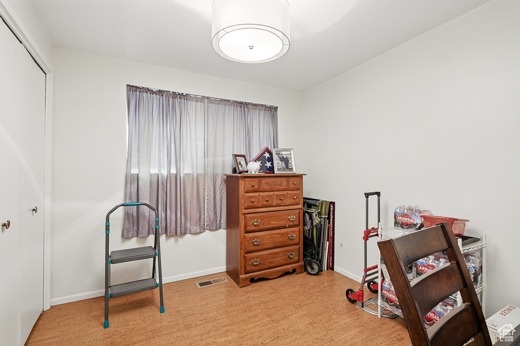 Bedroom with a closet, wood finished floors, and baseboards