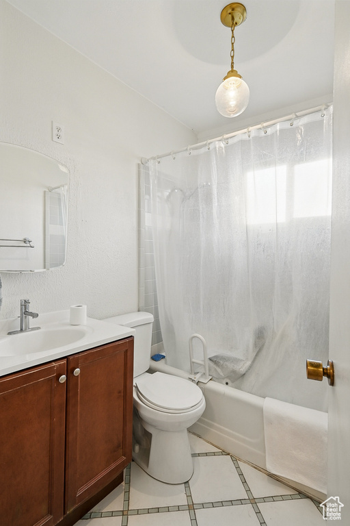 Full bath with vanity, tile patterned floors, shower / tub combo, toilet, and inlaid floor details