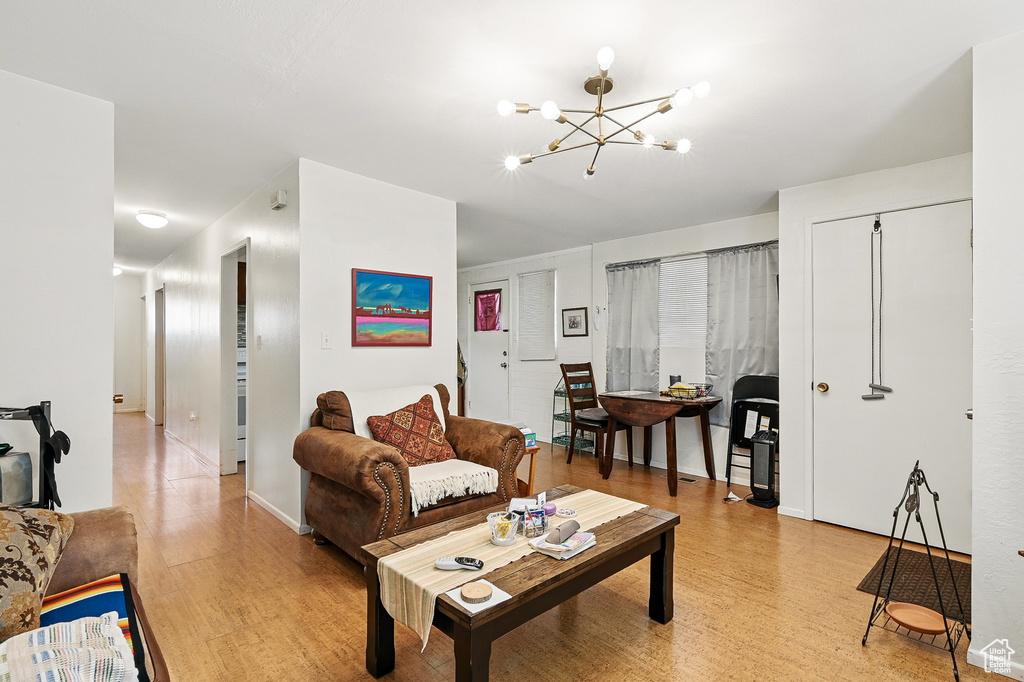 Living area with light wood-type flooring, a chandelier, and baseboards