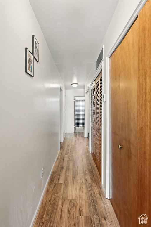 Corridor featuring wood finished floors and baseboards