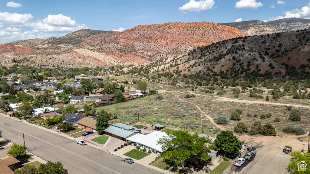 Aerial view of property's location with a mountainous background and nearby suburban area