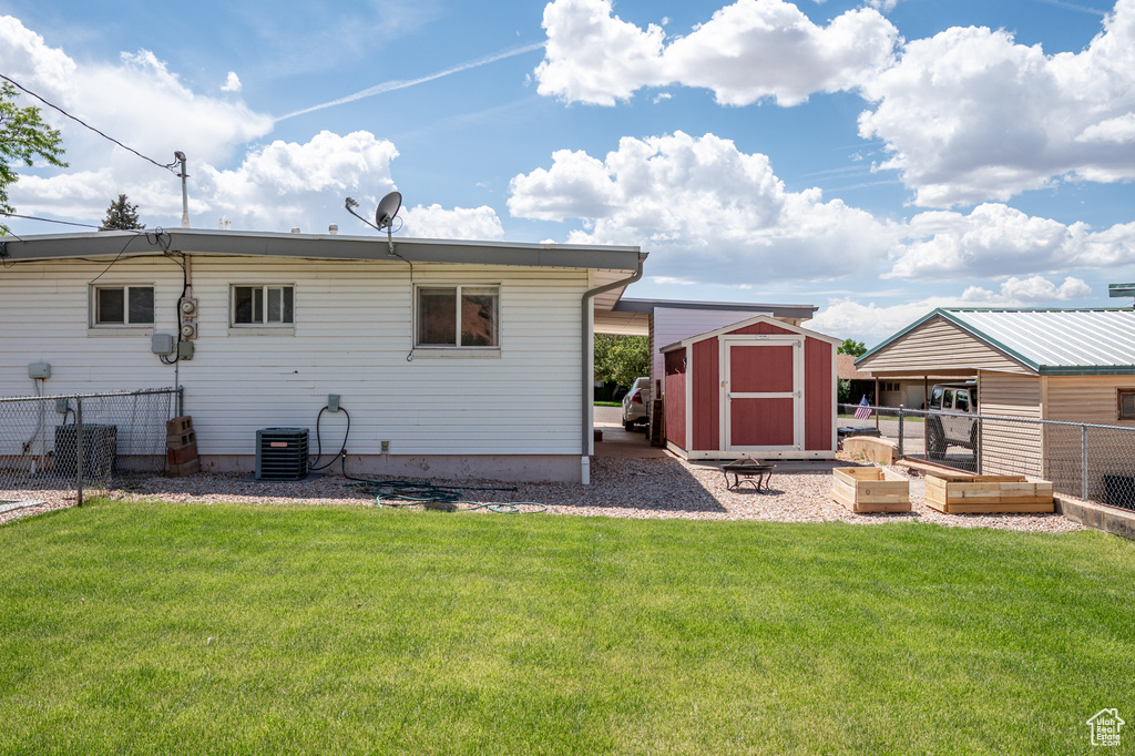 Rear view of house with central air condition unit and a vegetable garden