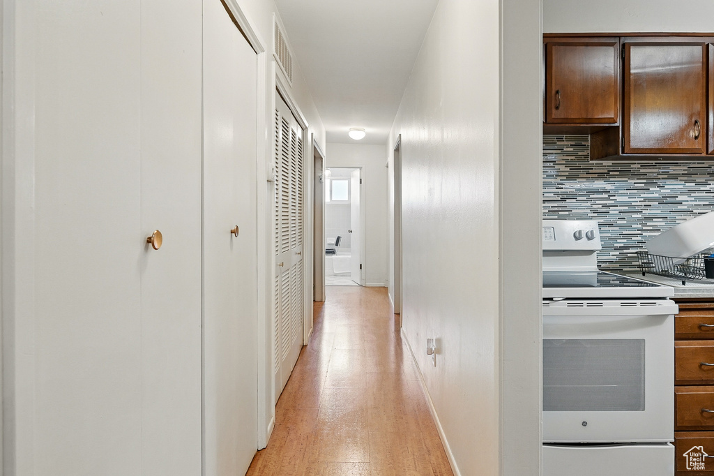 Hallway with light wood-style floors and baseboards