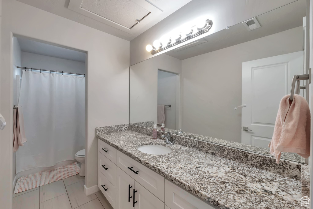 Bathroom with vanity, toilet, and a shower with shower curtain