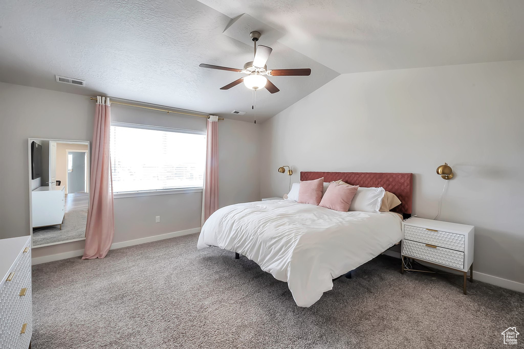 Bedroom with lofted ceiling, a ceiling fan, baseboards, and carpet flooring