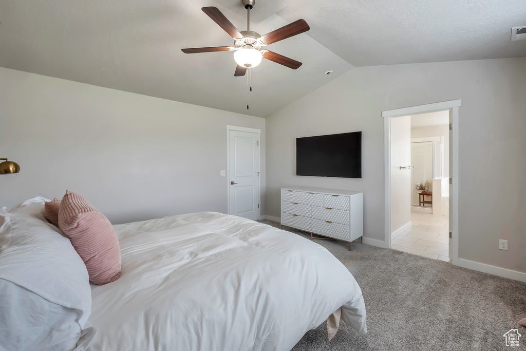 Carpeted bedroom with lofted ceiling, baseboards, and ceiling fan