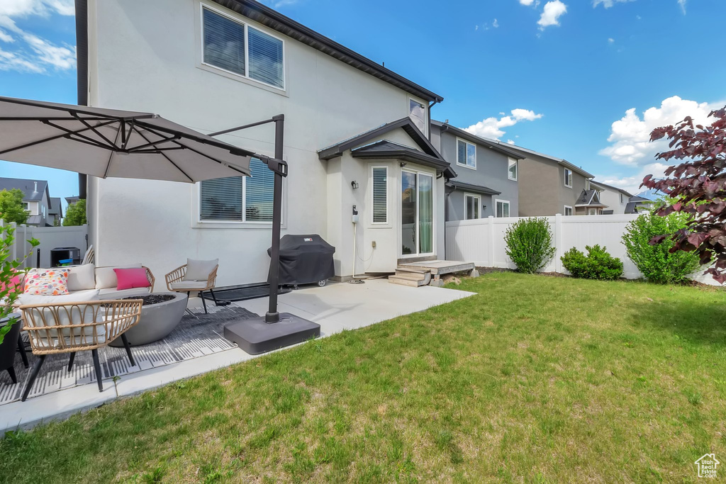 Rear view of house with stucco siding and a patio area