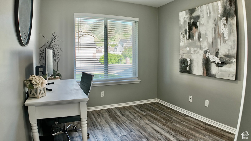Office with healthy amount of natural light, wood finished floors, and baseboards