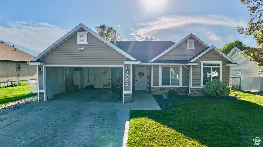 View of front of home with driveway, a garage, and stone siding