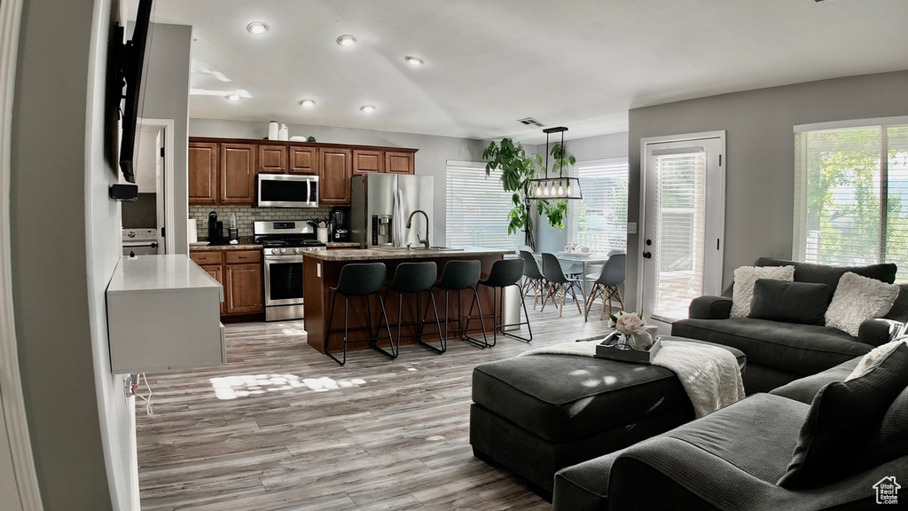 Living area with light wood-type flooring, a chandelier, and recessed lighting