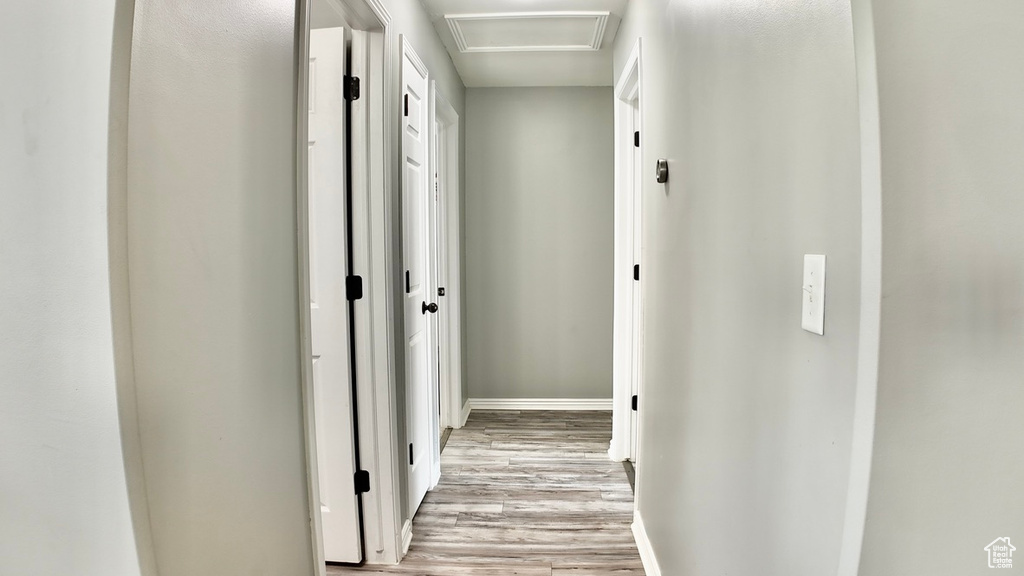 Hall with light wood-style flooring and baseboards