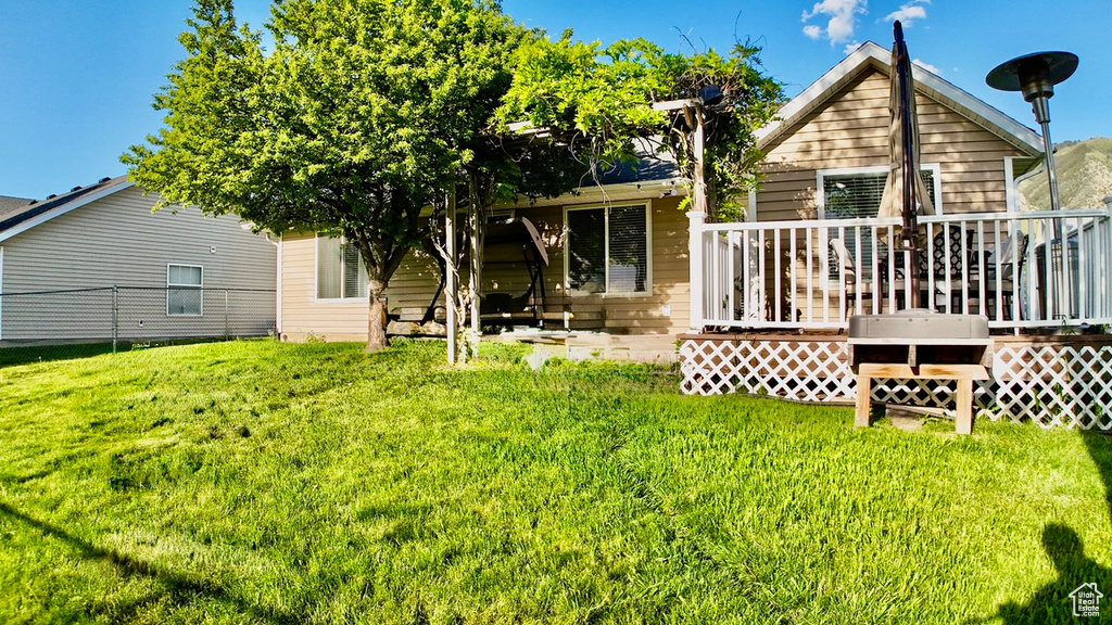 Back of house with a yard and a deck
