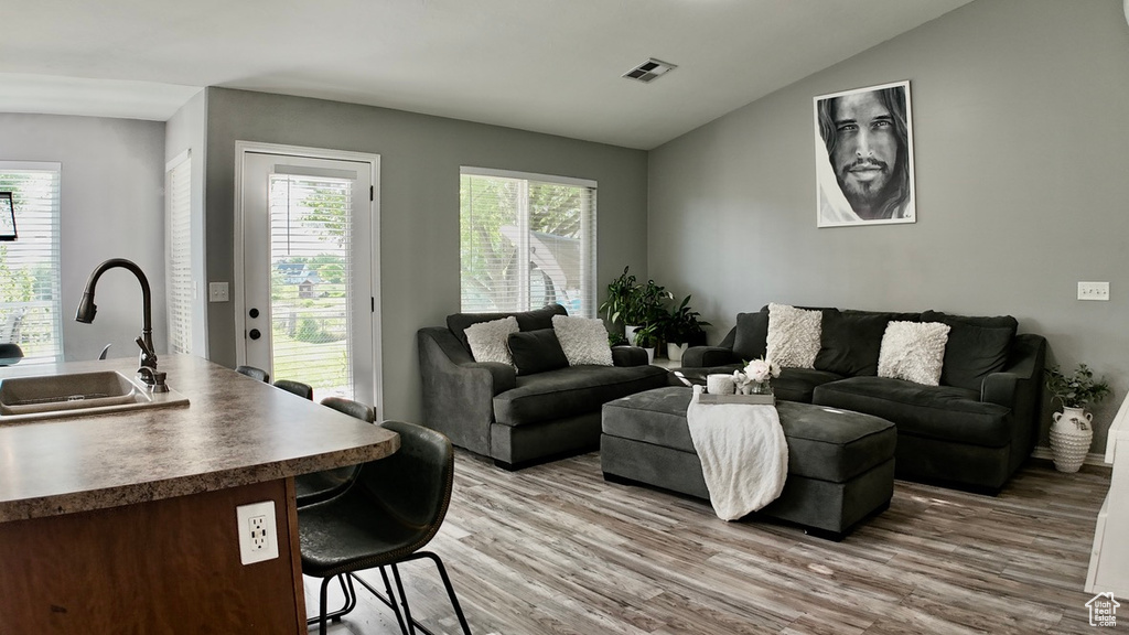 Living area featuring light wood-style floors and lofted ceiling