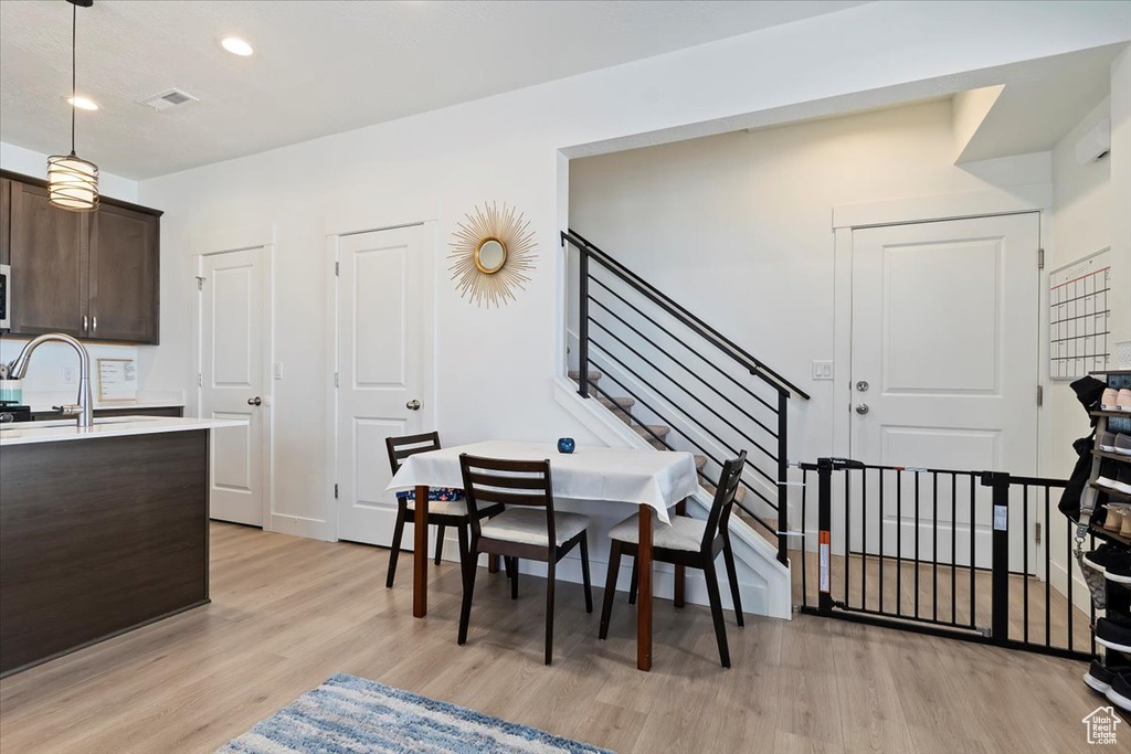 Dining area featuring light wood-style flooring, stairway, and recessed lighting
