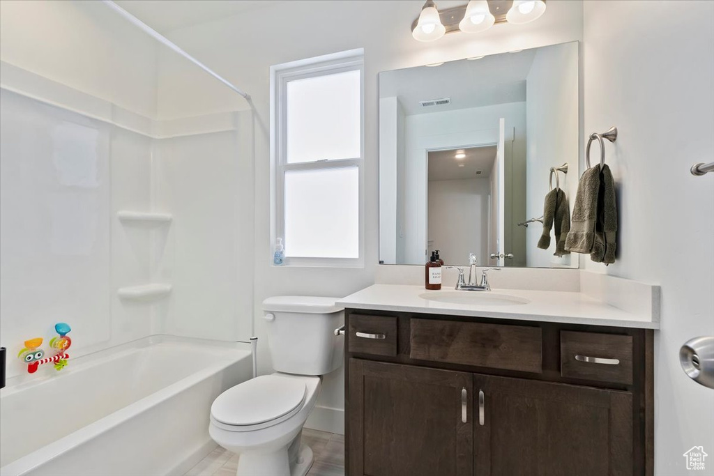 Full bath featuring vanity, toilet, and washtub / shower combination