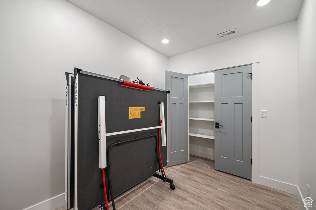 Interior space featuring wood finished floors, baseboards, and recessed lighting