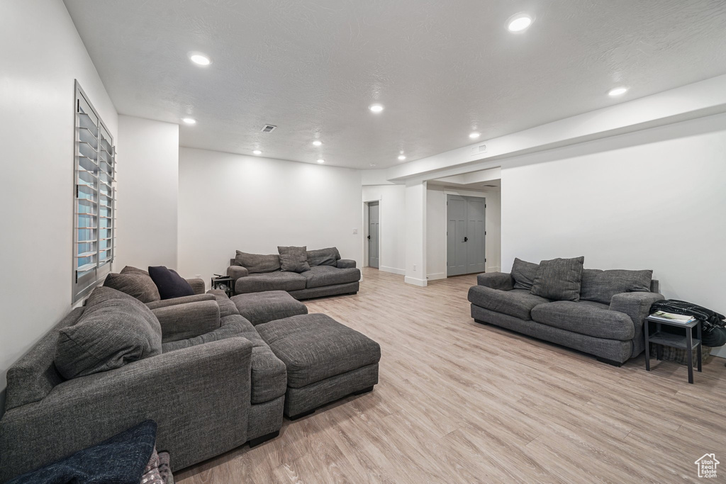 Living area featuring light wood finished floors and recessed lighting