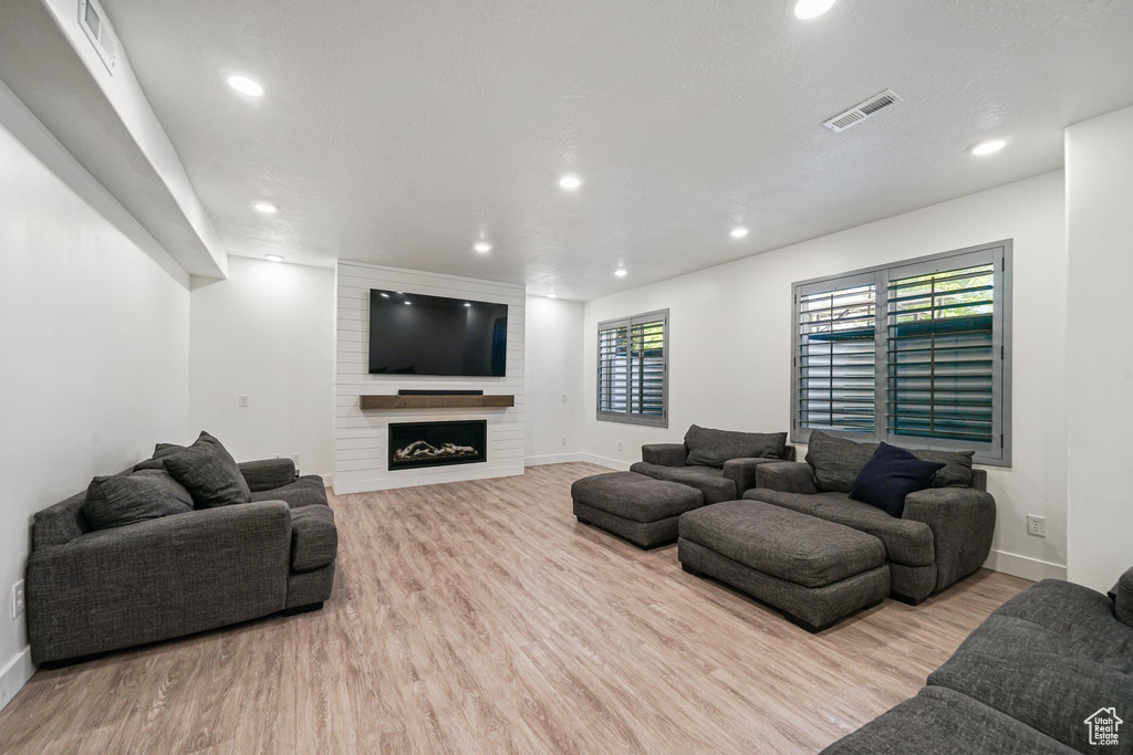 Living room with wood finished floors, baseboards, and recessed lighting