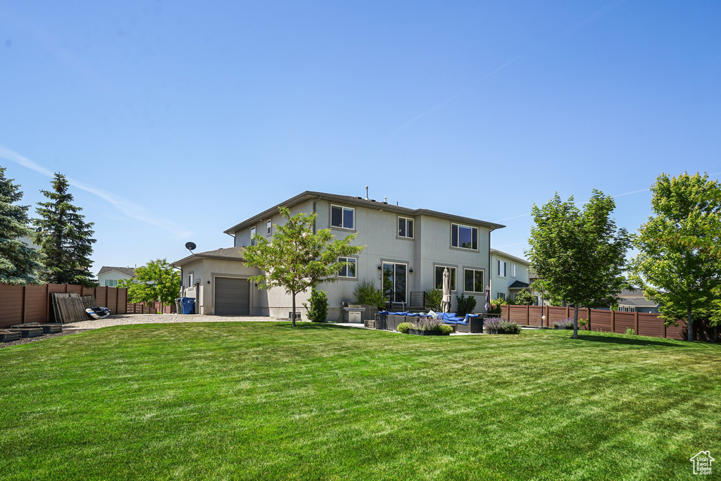 Back of property featuring stucco siding, driveway, and an attached garage