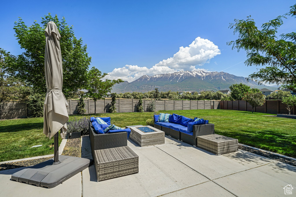 View of patio with an outdoor living space with a fire pit and a mountain view