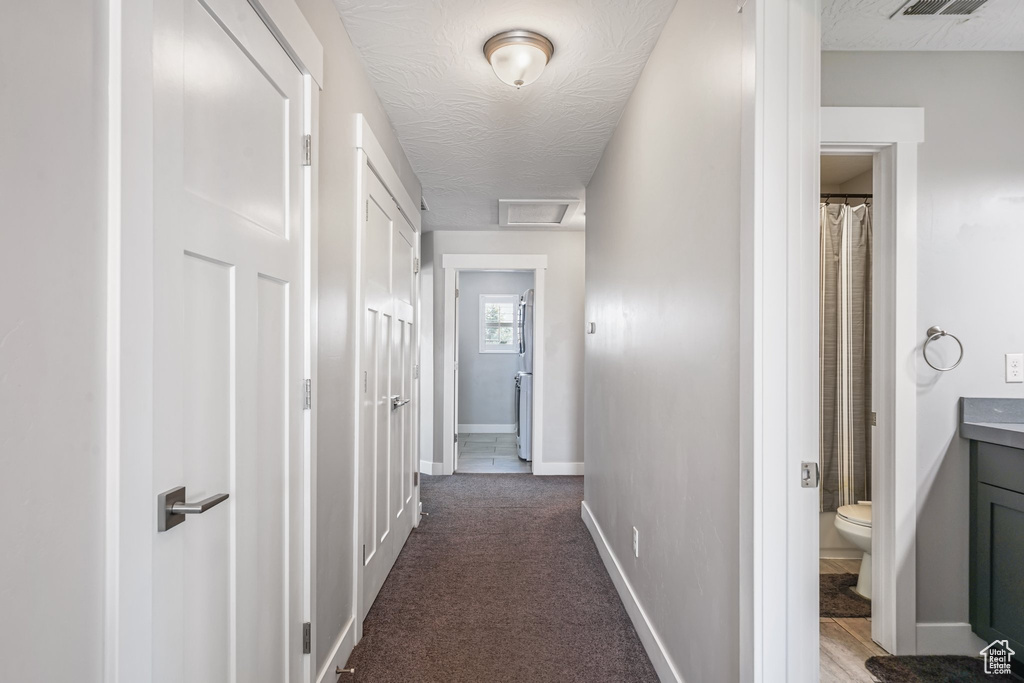 Corridor featuring baseboards and carpet