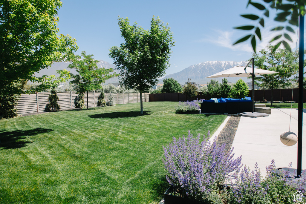 View of yard featuring an outdoor living space, a mountain view, and a patio area