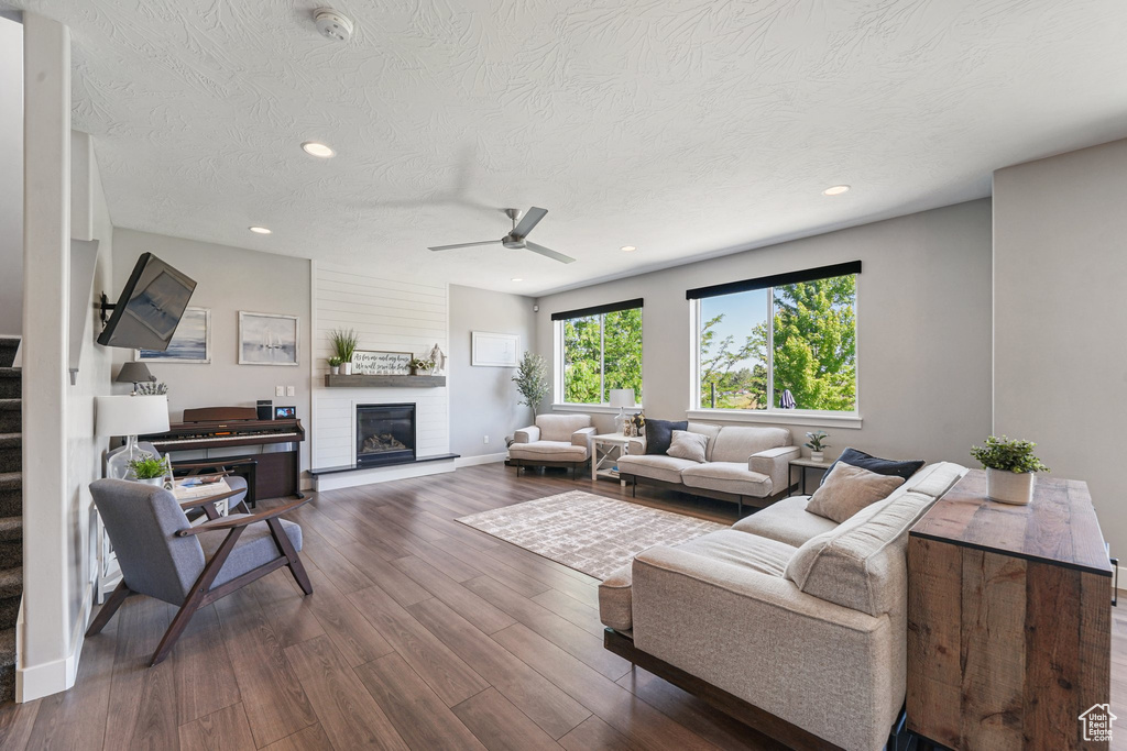 Living area with stairs, dark wood-style flooring, recessed lighting, ceiling fan, and a textured ceiling