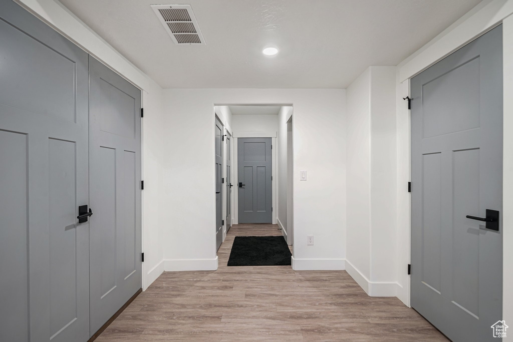 Hall featuring baseboards, recessed lighting, and light wood-type flooring