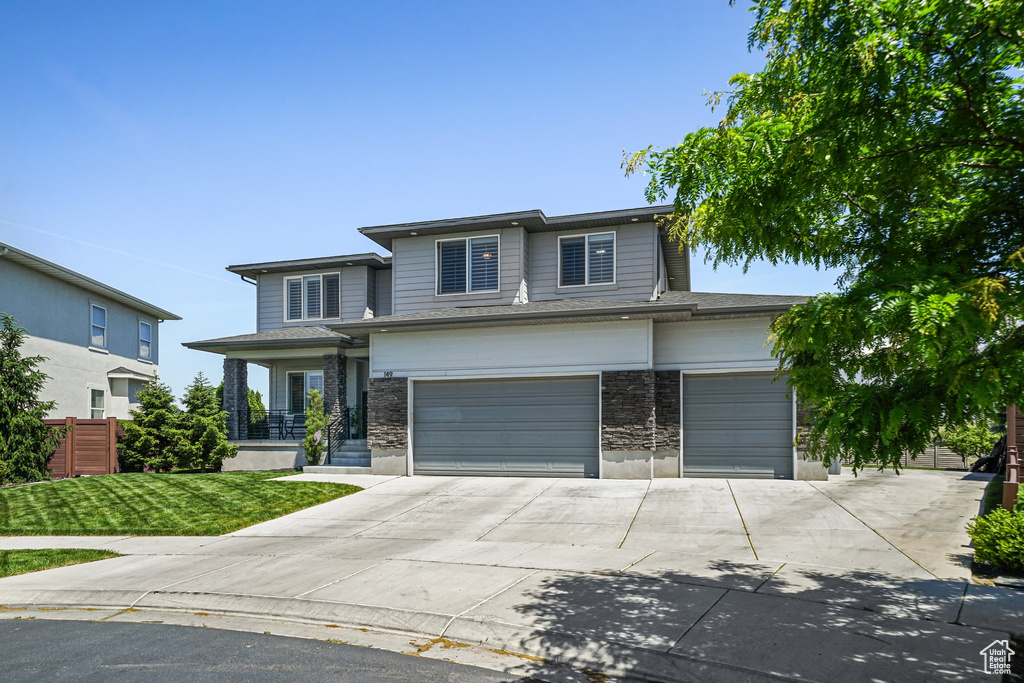 View of front facade featuring driveway and an attached garage