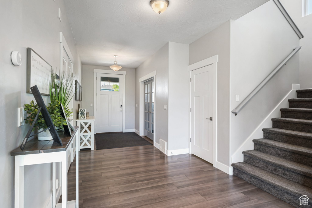 Entryway featuring stairway, dark wood finished floors, and baseboards