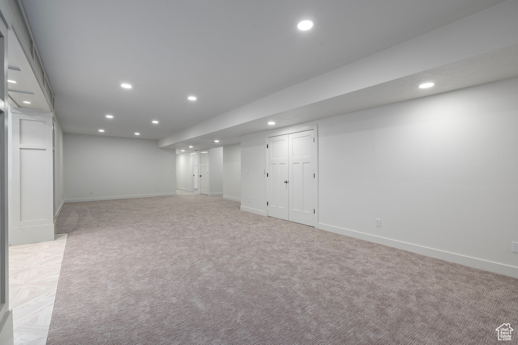Finished below grade area with recessed lighting, baseboards, and light colored carpet