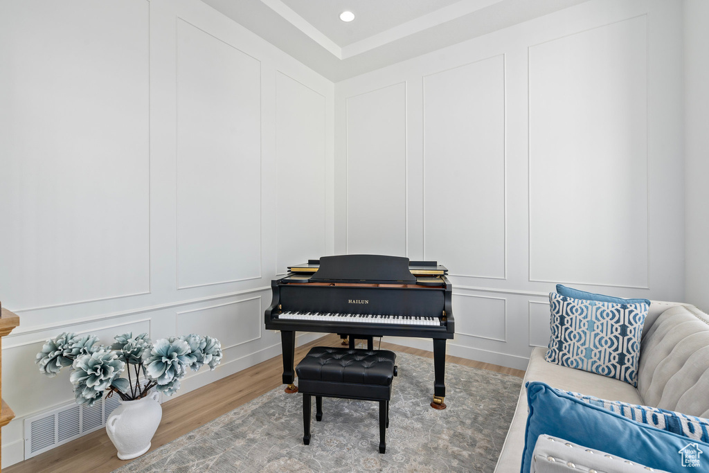 Sitting room with a decorative wall, wood finished floors, and recessed lighting