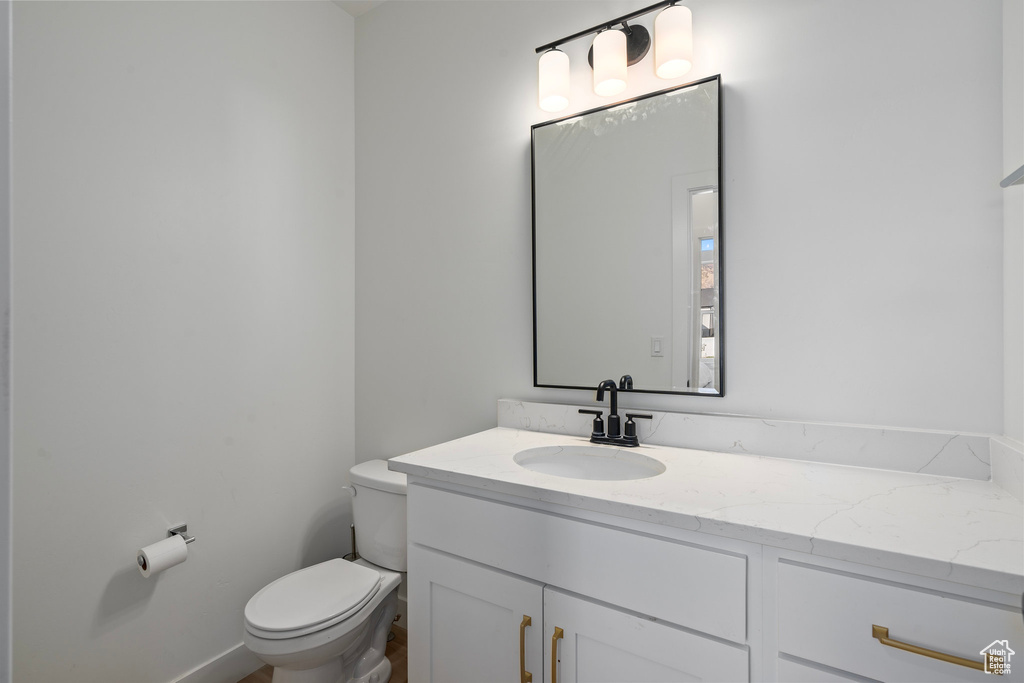 Half bathroom featuring toilet and vanity