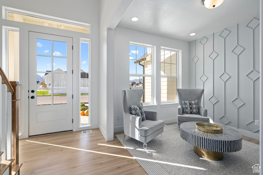 Foyer featuring healthy amount of natural light, baseboards, stairs, wood finished floors, and recessed lighting