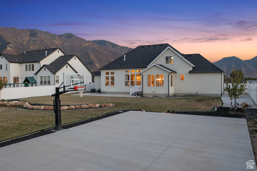 Modern inspired farmhouse with a mountain view, stucco siding, and basketball court