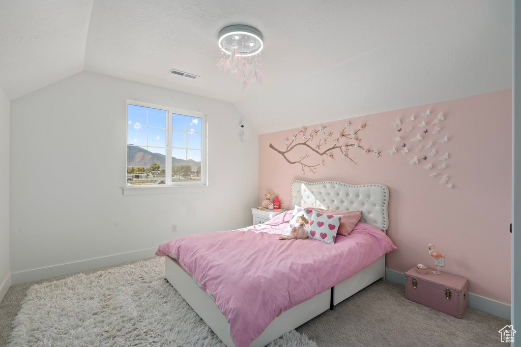 Bedroom with vaulted ceiling, baseboards, and carpet flooring