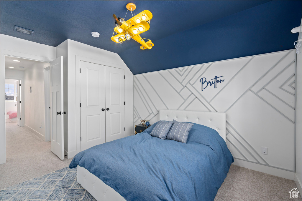 Bedroom with carpet, a closet, and lofted ceiling