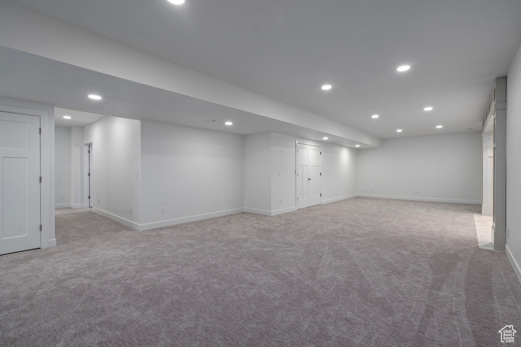 Finished below grade area featuring recessed lighting, light colored carpet, and baseboards