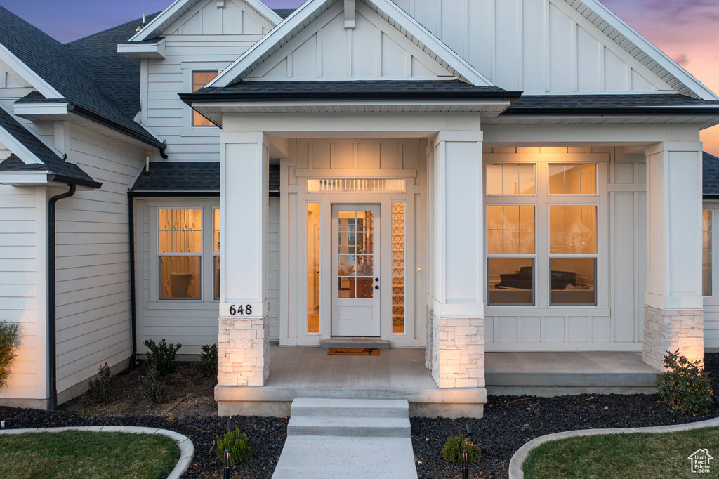 Property entrance featuring board and batten siding and a shingled roof