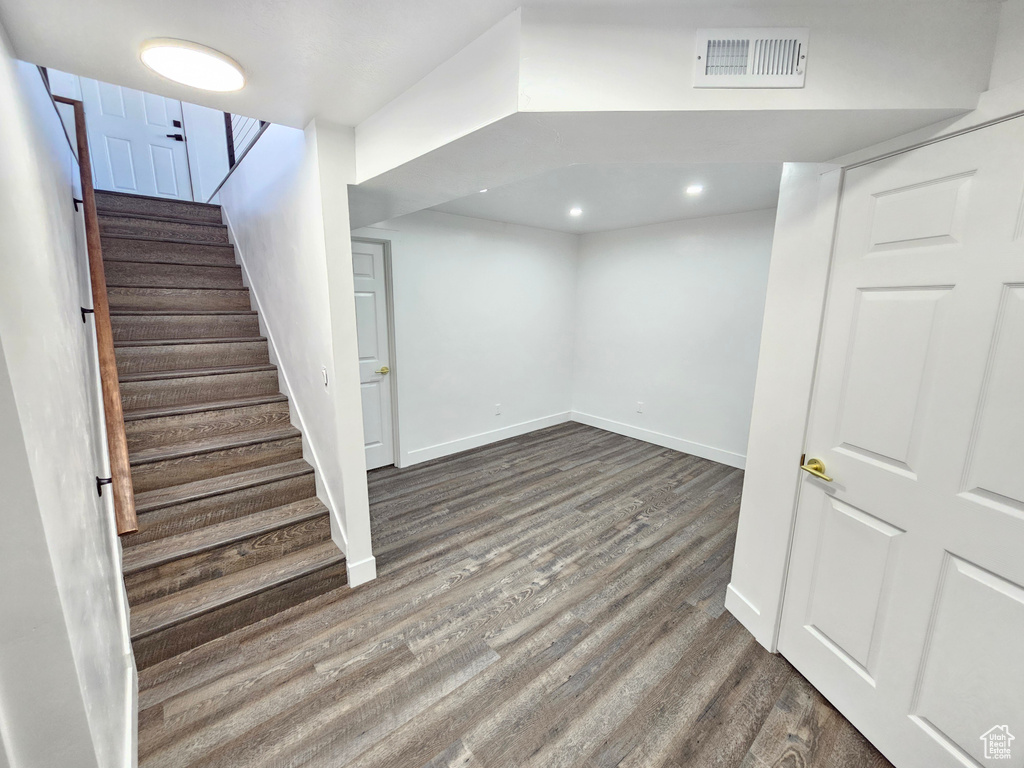 Finished below grade area with wood finished floors, stairs, baseboards, and recessed lighting