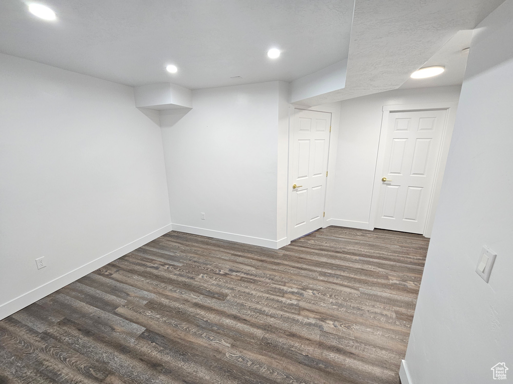 Finished basement with baseboards, dark wood-type flooring, and recessed lighting